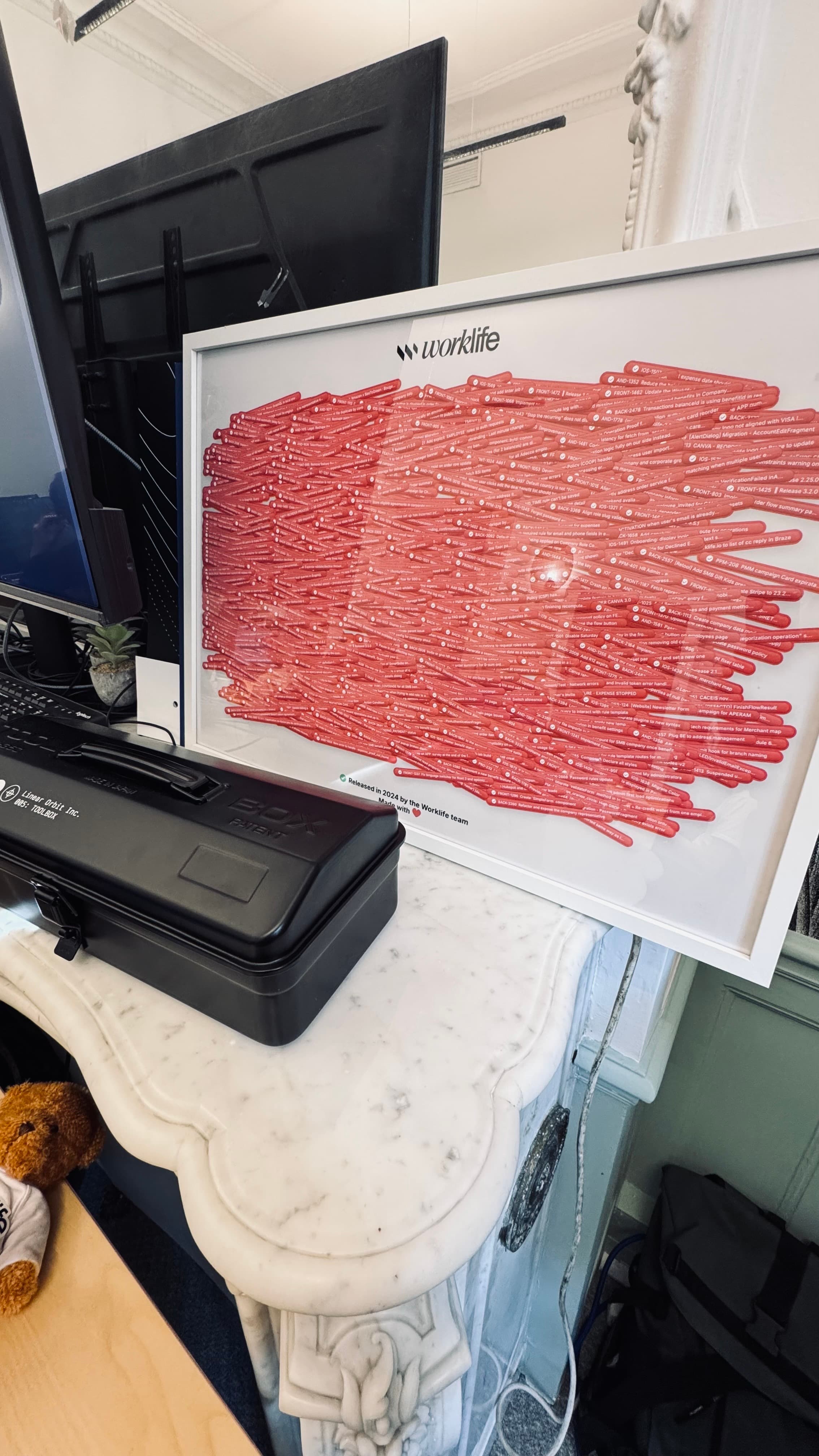Pink Ticket Poster leaning on a marble table near a printer